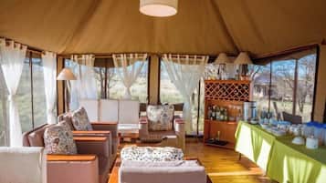 Een accommodatie met tenten, een zithoek, een bar en uitzicht op de natuur.