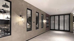 Een modern interieur met een betonnen muur, grote ramen en een trap.