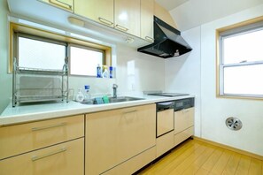 A compact kitchen with a window, a sink, and a dishwasher. - Beyond Comfort Shinjuku Okubo (Tokyo)