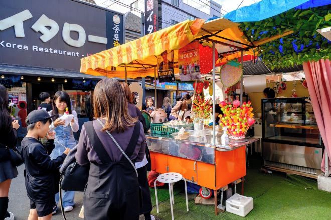 A food stall with a yellow canopy and a display of food items.
