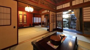 Een traditionele Japanse kamer met tatami vloeren, schuifdeuren en een lage houten tafel met een theeset.