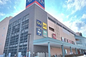 A building with a prominent GU loft sign, a large glass facade, and a covered entrance area. - THE SMILE (Sapporo)
