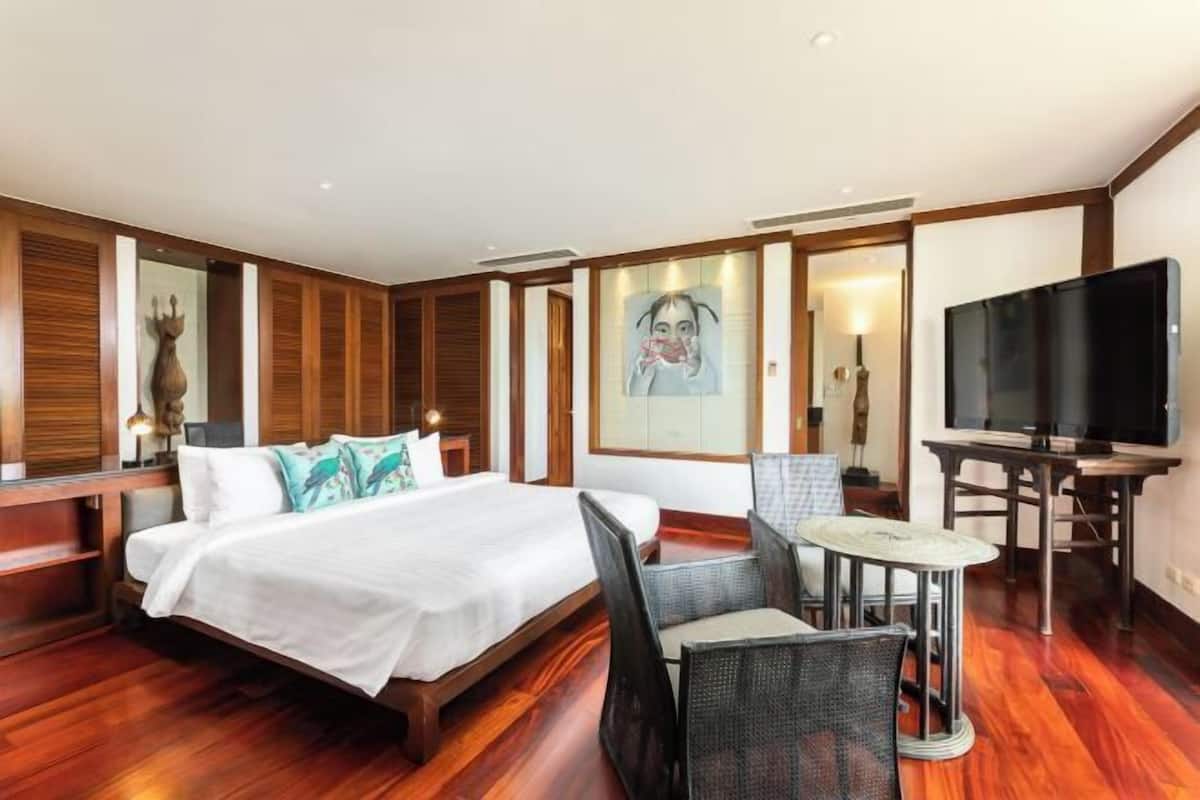 Een hotelkamer met een bed, een televisie, een tafeltje en een stoel.