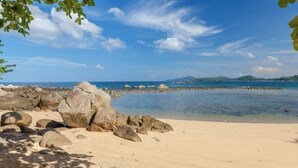 Una platja amb roques grans i aigua blava cristal·lina.