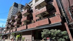 A multi-story building with balconies, a storefront, and potted plants. - Lions Mansion Dogenzaka SHIBUYA (Tokyo)