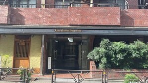 A hotel entrance with a brick facade, a wooden door, and a sign above the entrance. - Lions Mansion Dogenzaka SHIBUYA (Tokyo)
