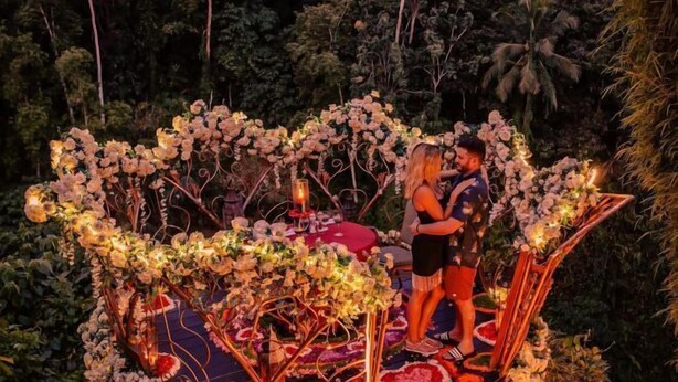 A couple embracing on a decorated outdoor platform with floral arrangements and candles. - Villa Cella Bella ( Bali instaworthy villa ) (Bali)