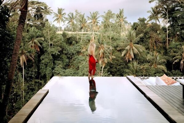 A person standing on a reflective surface with a view of dense tropical vegetation. - Villa Cella Bella ( Bali instaworthy villa ) (Bali)