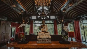 A room with a wooden ceiling, a chandelier, and a statue on a table. - Villa Cella Bella ( Bali instaworthy villa ) (Bali)