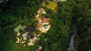 An aerial view of a residential area with multiple houses surrounded by dense greenery and a river. - Villa Cella Bella ( Bali instaworthy villa ) (Bali)