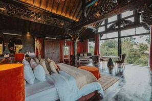 A spacious bedroom with a large bed, a sitting area with a table and chairs, and a view of the outdoors. - Villa Cella Bella ( Bali instaworthy villa ) (Bali)