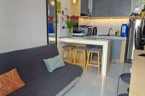 A modern kitchen with grey cabinets, a white countertop, and a stainless steel refrigerator. - BMF Homestay Jacuzzi Villa 1 (entire house) (Tacloban)