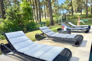 Outdoor lounge chairs with cushions, a small table, and a decorative item. - BelArt Golf Villa (Charneca de Caparica e Sobreda)