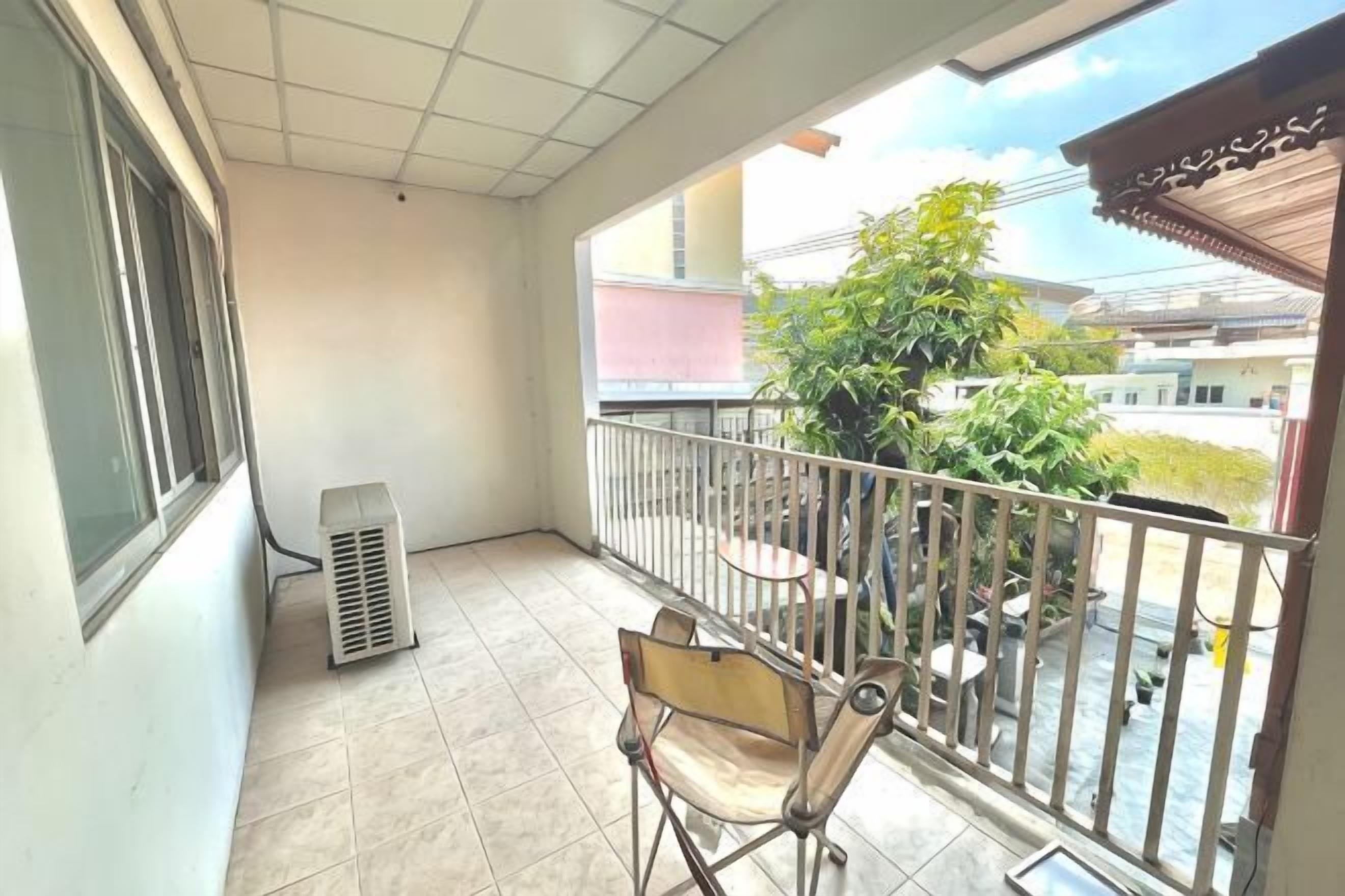 A balcony with a chair, a table, and a potted plant.