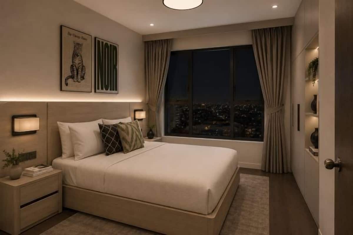 Ein Schlafzimmer mit einem großen Bett, Nachttischlampen, einem Beistelltisch, einem Fenster mit Vorhängen und Blick auf die Stadt.