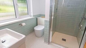 A bathroom with a shower, toilet, sink, and window. - Swallows Croyde 3 Bedrooms, Sleeps 6, Beach Chale (Braunton)