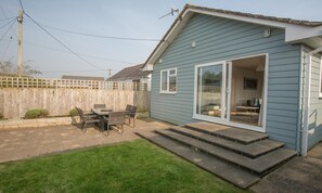 A residential property with a patio area, a wooden fence, and a sliding glass door leading to an interior space. - Swallows Croyde 3 Bedrooms, Sleeps 6, Beach Chale (Braunton)