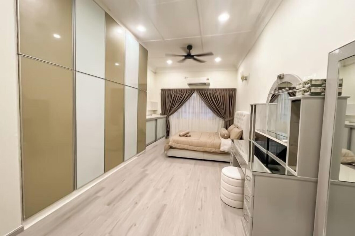 A bedroom with a bed, a ceiling fan, an air conditioning unit, and a wardrobe.