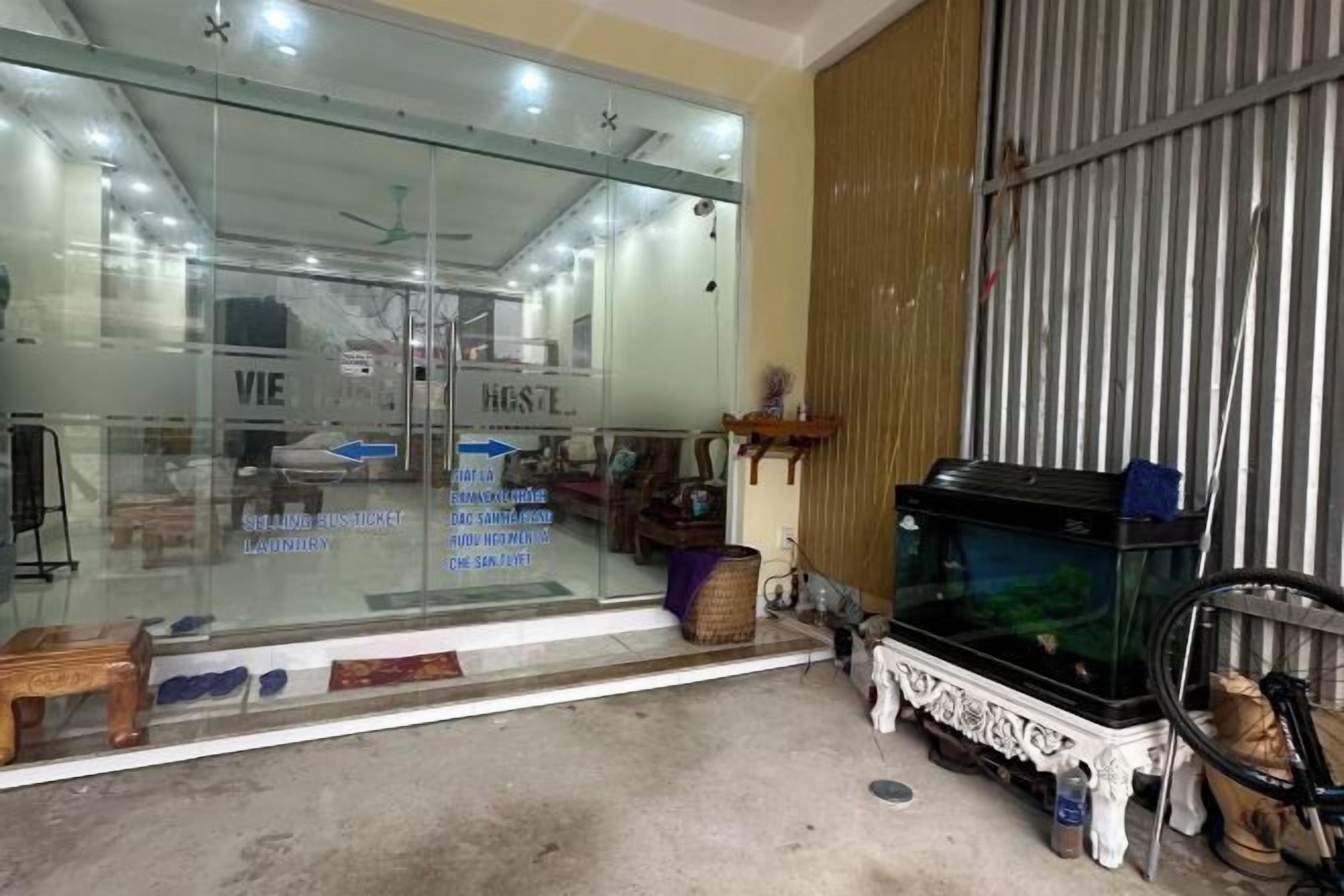 Une pièce avec un mur en verre, un lit, une commode et un aquarium.