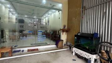 Une pièce avec un mur en verre, un lit, une commode et un aquarium.