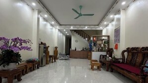 A spacious lobby with a high ceiling fan, a staircase leading to upper floors, and a reception desk. - VietHung Hostel-Motorbikes Renta-Tuor (Ha Giang)