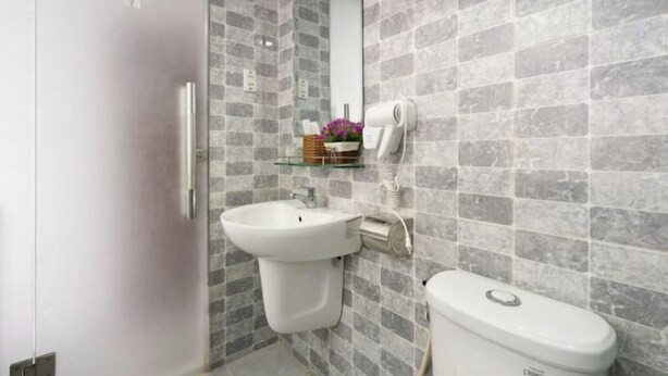 Een badkamer met een witte wastafel, toilet en spiegel.