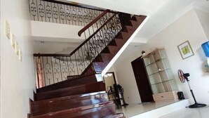 A wooden staircase with a metal railing leading to an upper floor. - Bluewaves Resort Moalboal by Hiverooms (Moalboal)