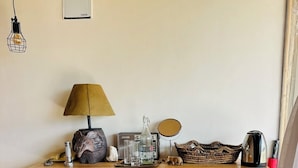 A wooden table with a lamp, a radio, a mirror, and various decorative items.