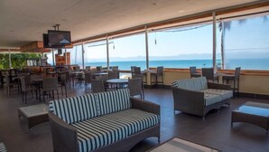 A spacious outdoor seating area with wicker furniture and a large TV screen.