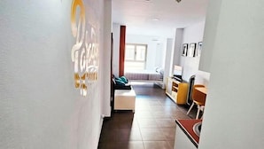 A hallway leading to a bedroom with a bed, a desk, and a chair. - Lala Loft, Las Canteras (Las Palmas)