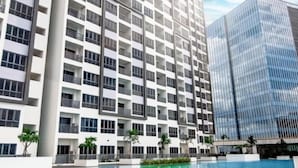 Un hôtel moderne doté d’une piscine, de nombreux balcons et d’une façade en verre.