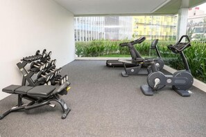 A gym with stationary bikes, treadmills, and weight machines.