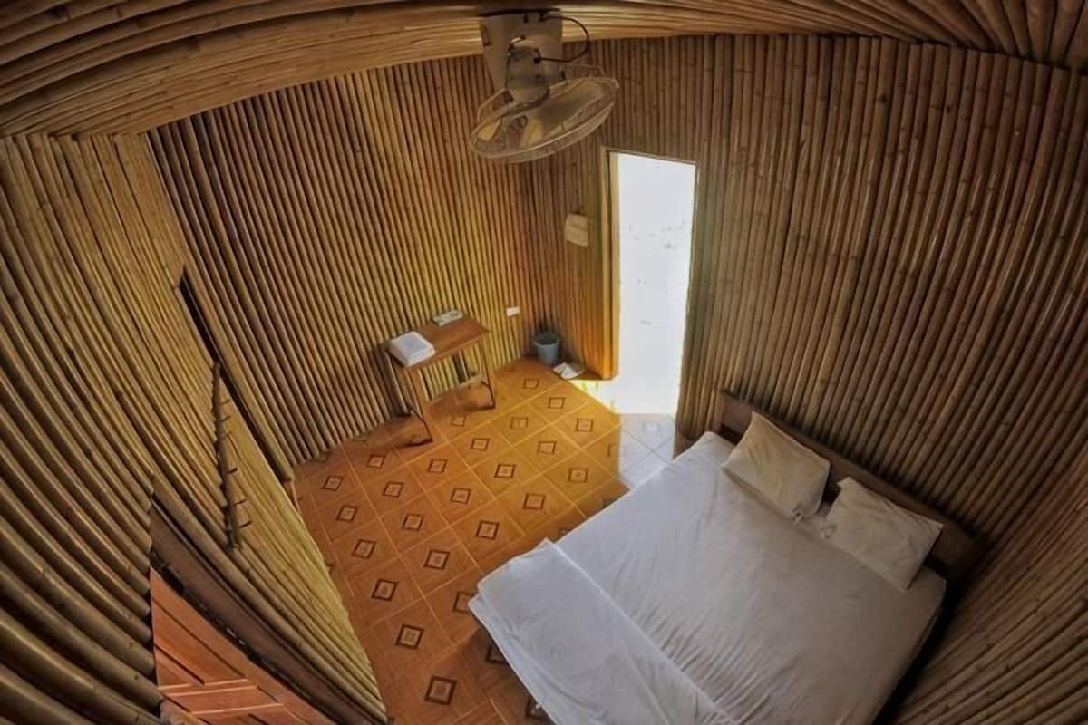 Une pièce avec un lit, une petite table et une chaise.