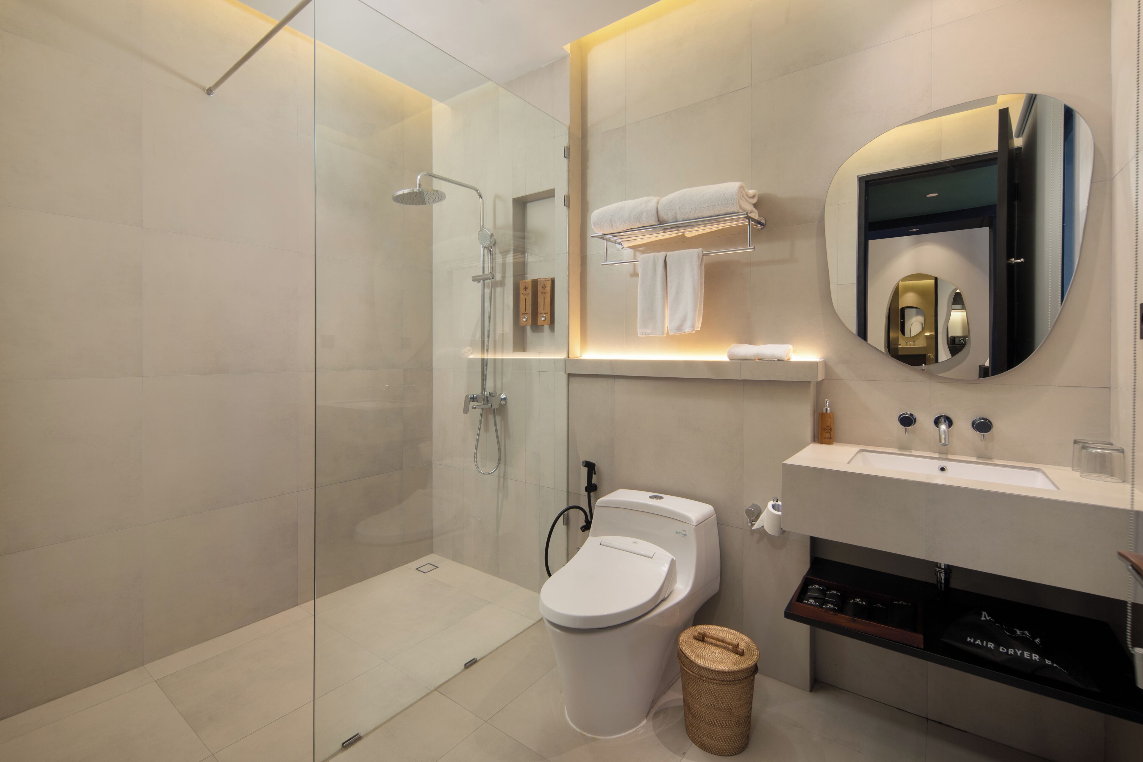 A modern bathroom with a glass-enclosed shower, a toilet, a sink, and a mirror.
