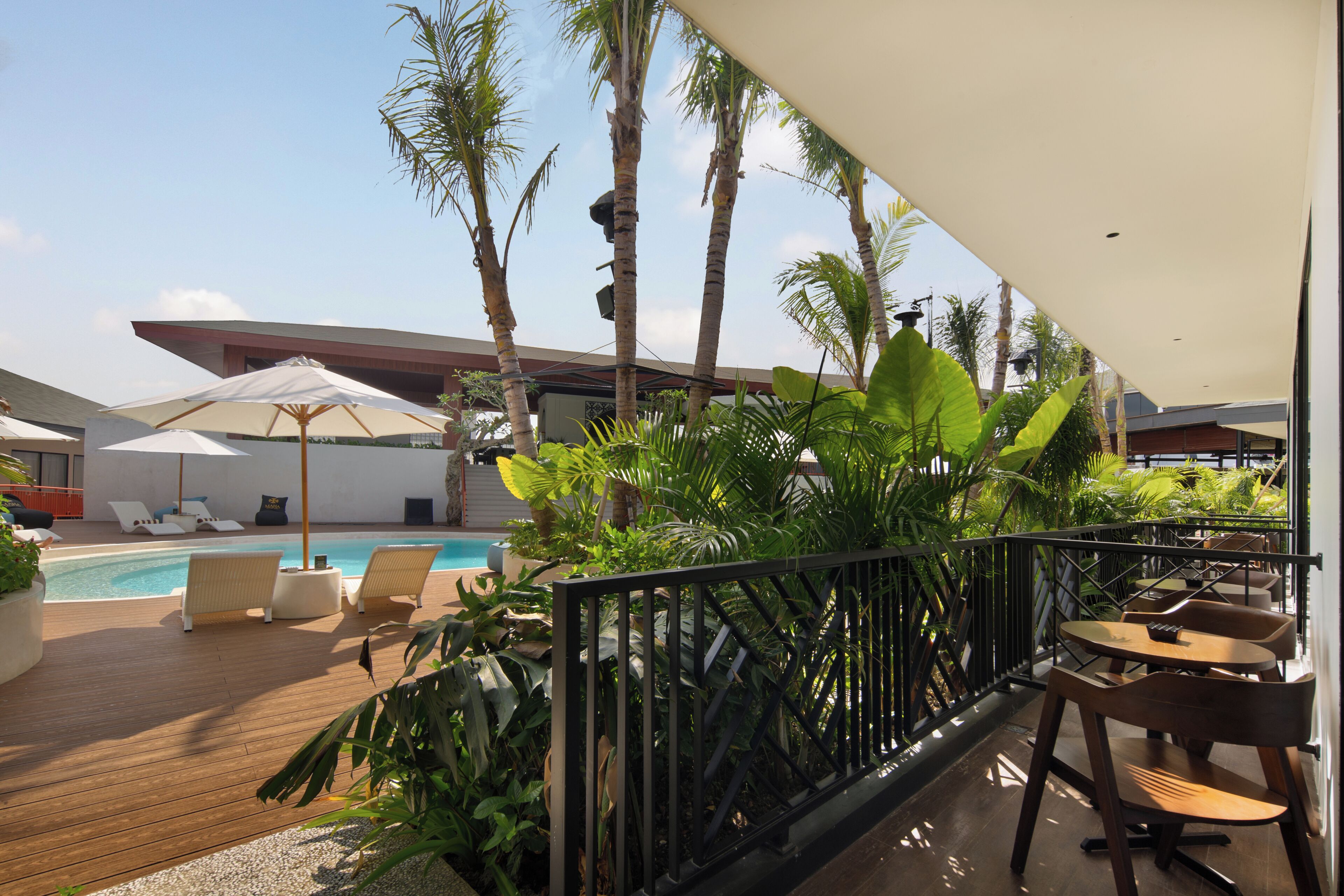 Ein Poolbereich mit Liegestühlen, Sonnenschirmen und einer Holzterrasse.