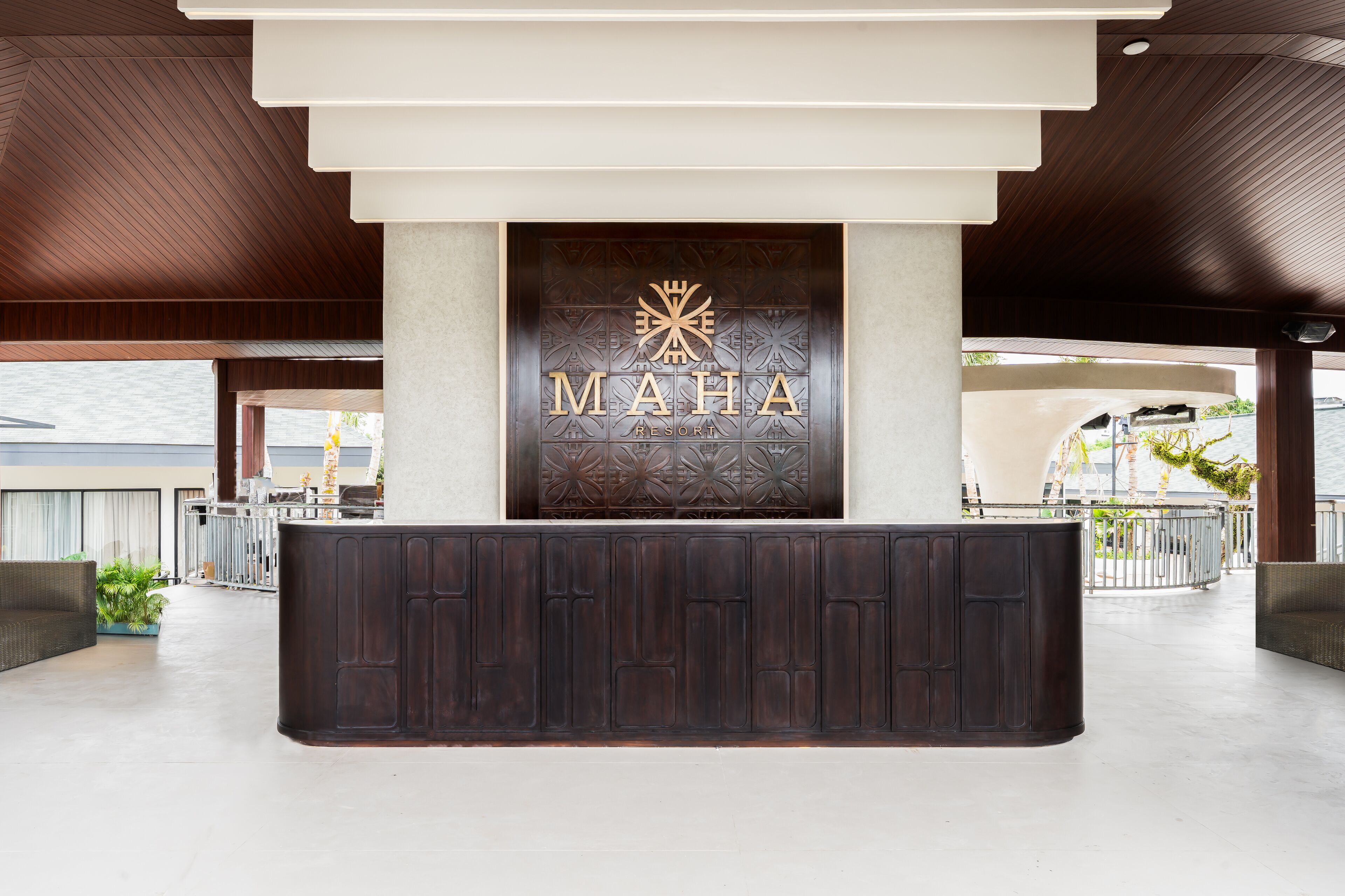 A reception desk with a logo and the name "MAHA RESORT" at the top.