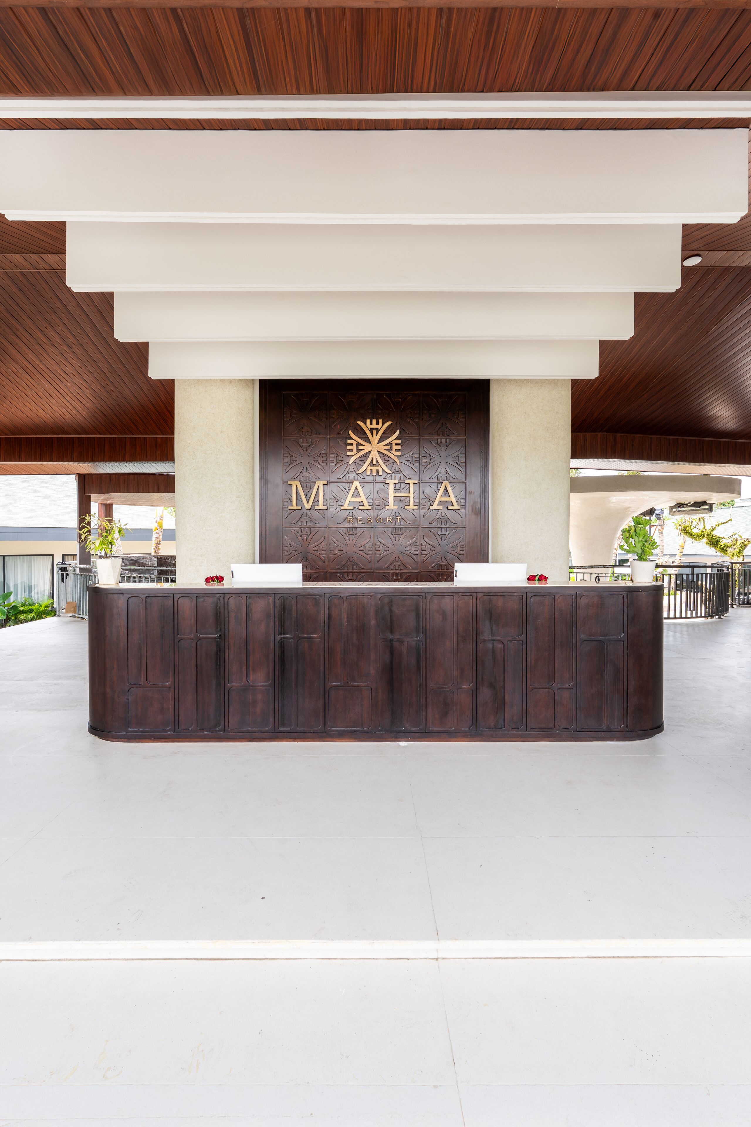 A reception desk with a wooden finish and a sign that reads "MAHA."