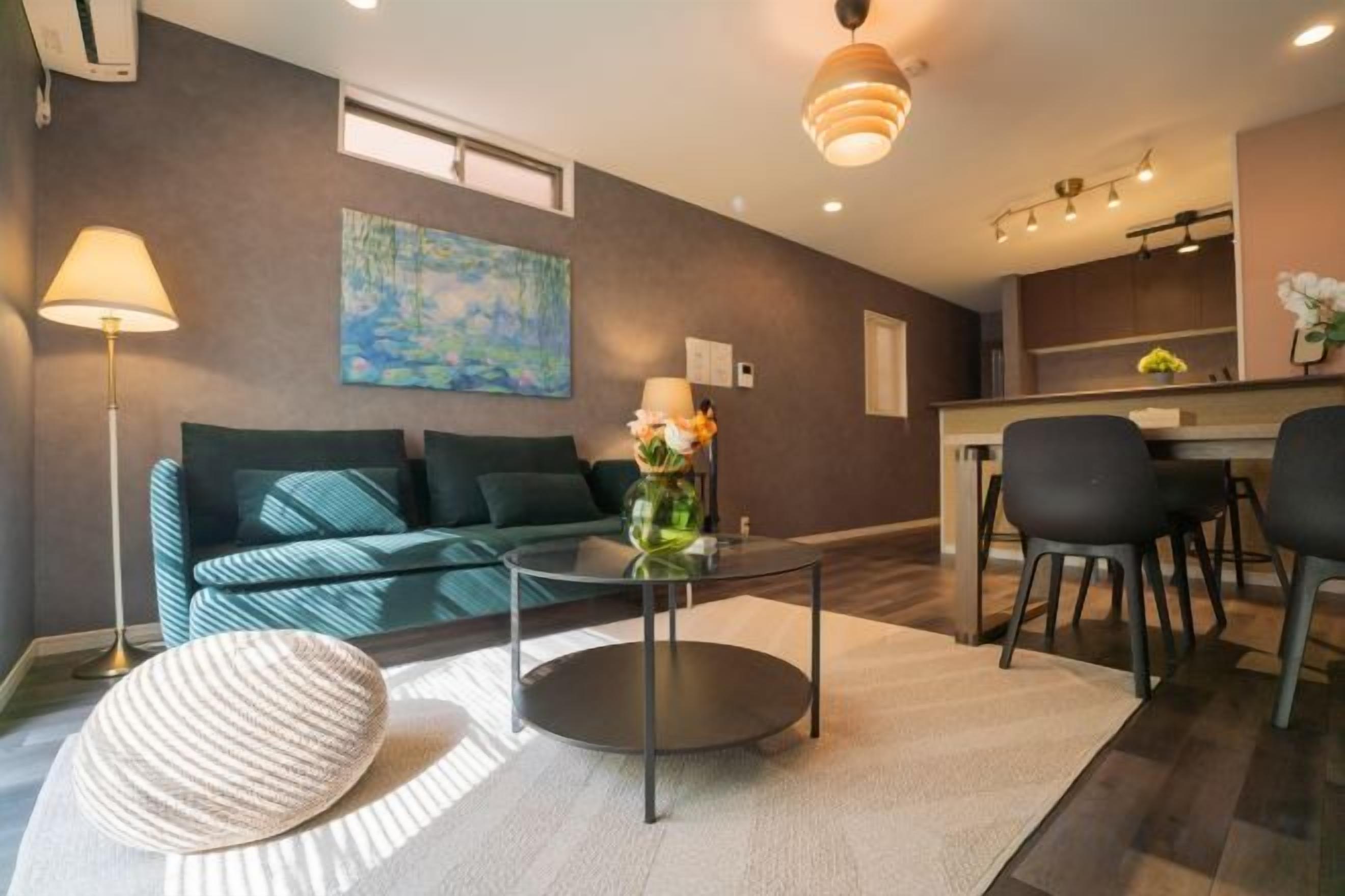 Un salon moderne comprenant un canapé, une table basse et un coin repas avec des chaises.