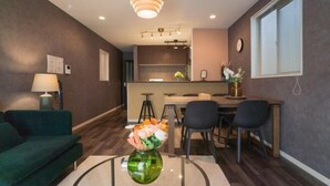 Una cocina moderna con comedor, un sofá y una mesa de centro con un florero.