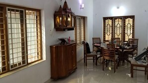 Un comedor con una mesa y sillas de madera, un armario y un ventilador de techo.
