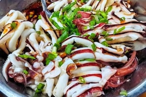 A bowl of sliced octopus with green onions and red chili peppers. - STARHOUSE (Kudat Division)