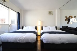 A hotel room with two beds, a large window, a wall-mounted heater, and a decorative wall piece. - Ideal Yuhigaoka (Osaka)