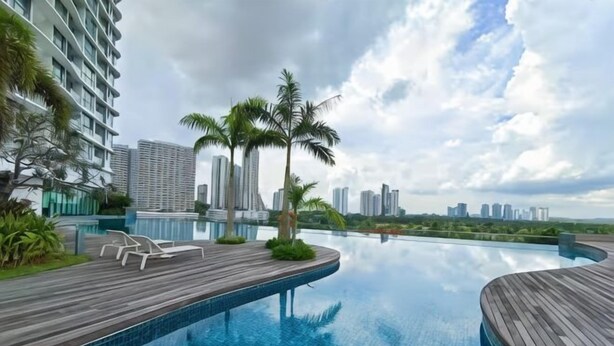 A rooftop infinity pool with wooden deck, palm trees, and a city skyline view. - 3806 Macrolink 6pax Cozy Legoland Netflix BySTAY (Iskandar Puteri)