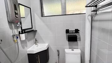 Een badkamer met een wastafel, spiegel, toilet en handdoekrek.