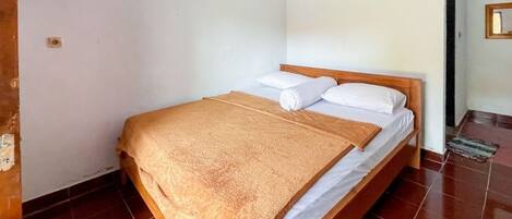 A single bed with a wooden frame, white bedding, and a brown blanket.