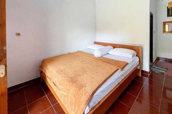 A single bed with a wooden frame, white linens, and a brown blanket.