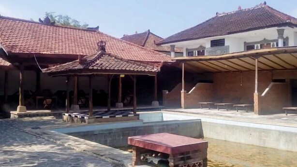A courtyard with a pool, covered seating areas, and a small brick structure. - Guest House Surya Ayu Permai Buleleng Mitra RedDoorz (Bali)