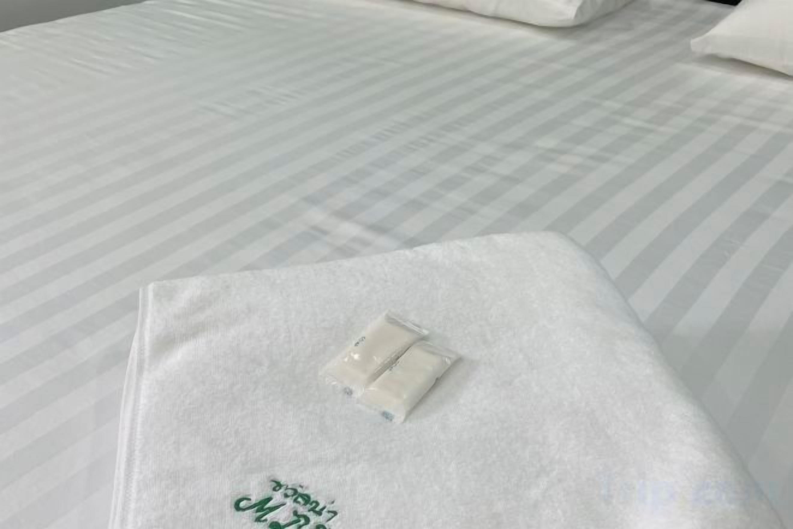 A bed with a white bedspread and a white pillow.