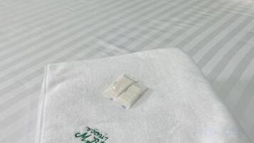 A bed with a white bedspread and a white pillow.