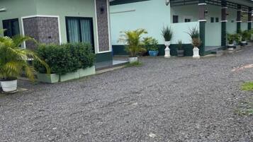A building with a gravel driveway and potted plants.